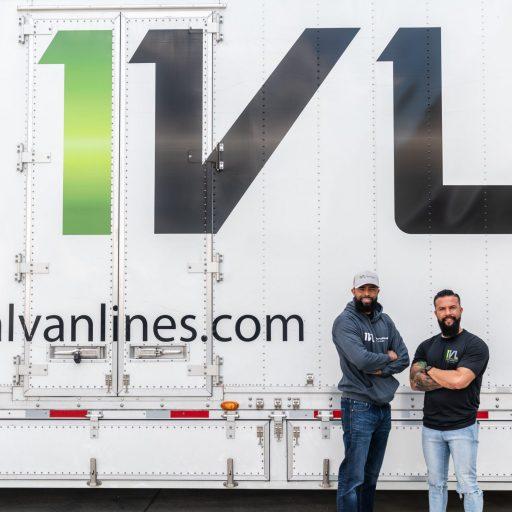 Two men standing in front of an International Van Lines storage unit
