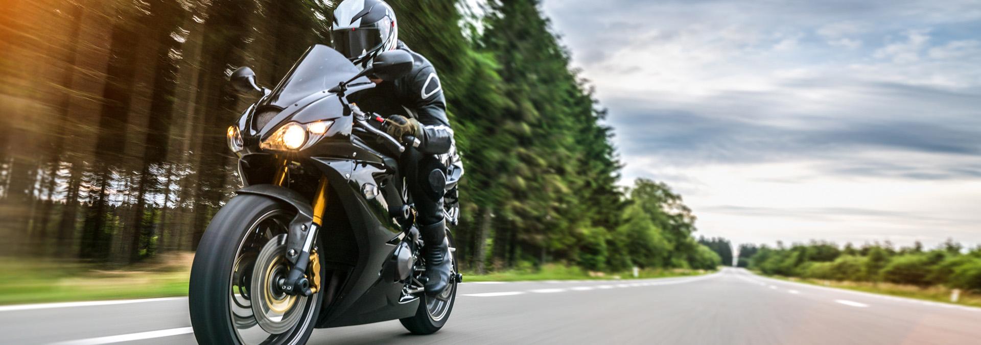 Motorcyclist speeding on an open road.