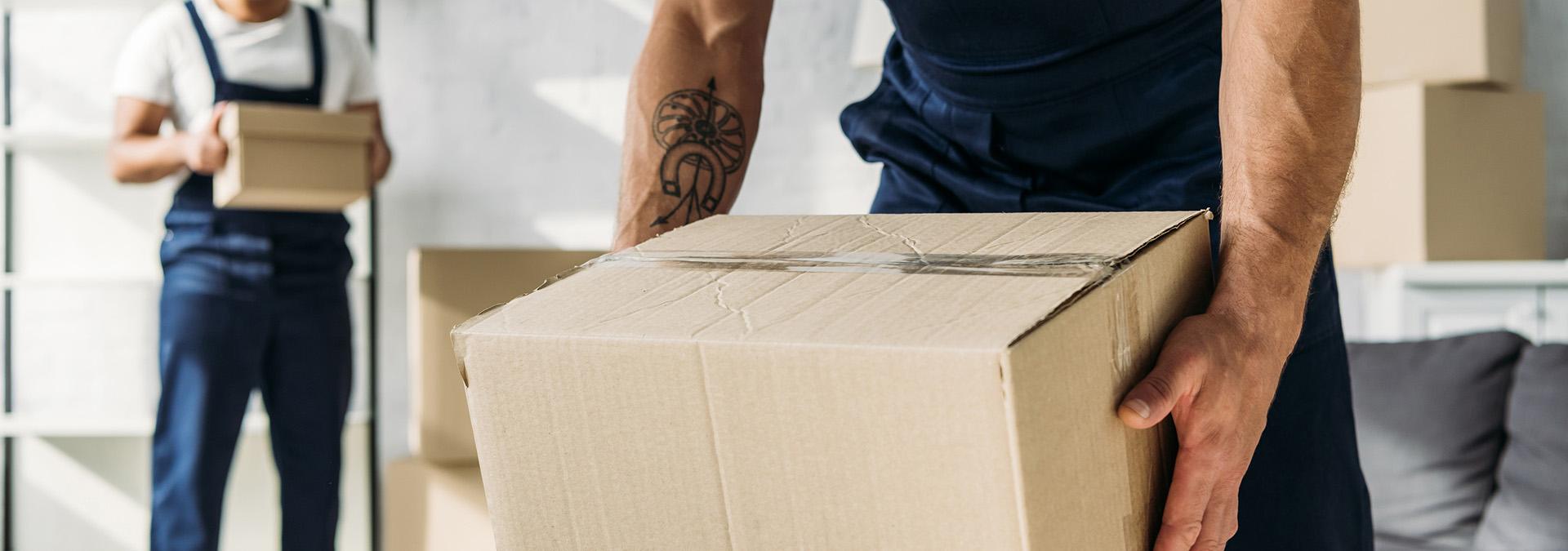 Professional movers carrying boxes during a home relocation.