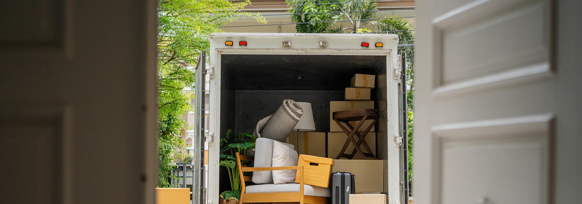 Open International Van Lines moving truck filled with packed boxes, furniture, and household items ready for transport.